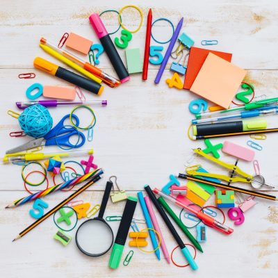 School supplies on white wooden background.
